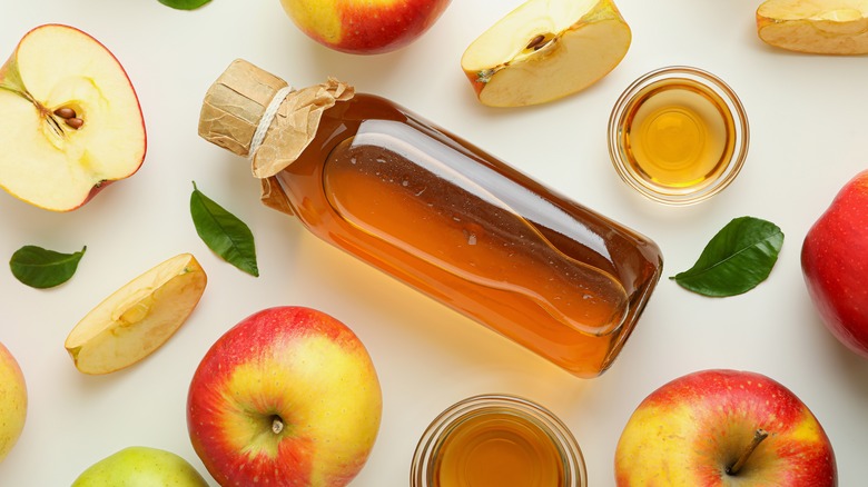 apple cider vinegar on a table with apples