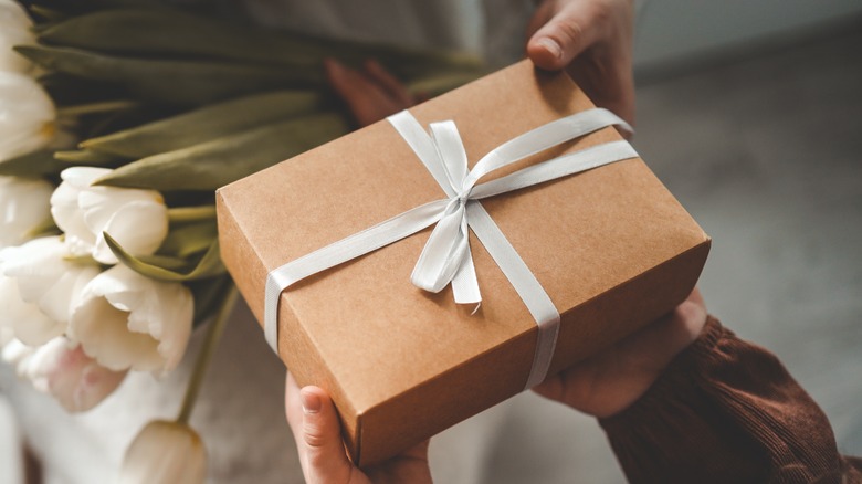 Person giving a box with bow