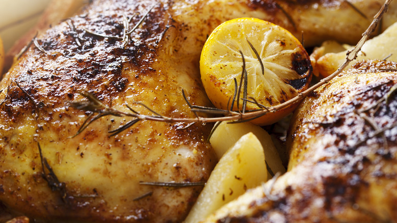 Closeup of roast chicken with lemon and thyme