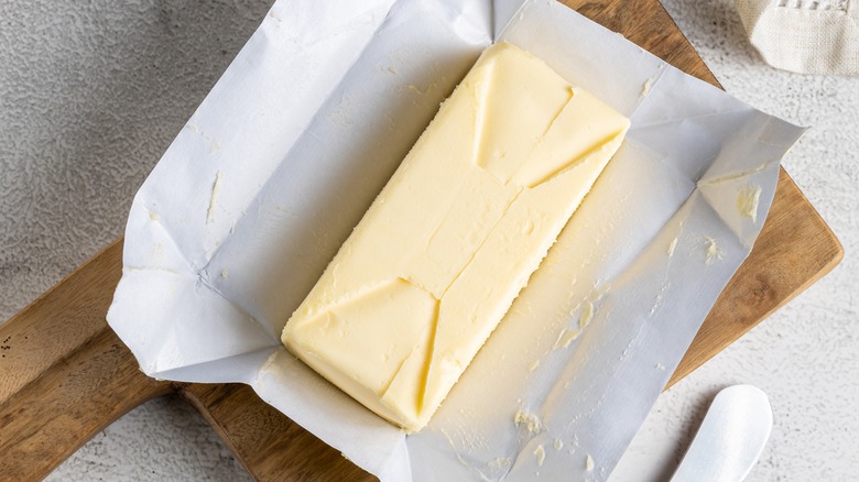 unwrapped butter on wooden board