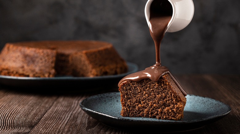 Pouring chocolate ganache onto chocolate cake