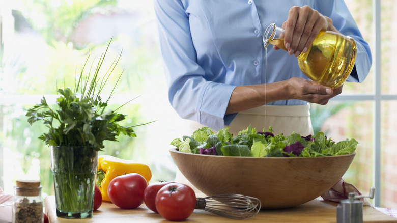 Woman pouring salad dressing