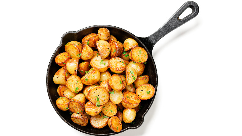 roasted potatoes in skillet on white background