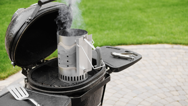 smoking chimney starter on top of grill