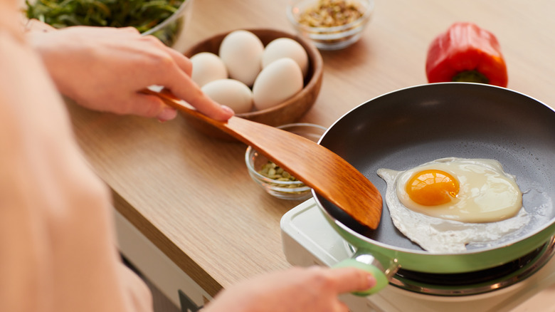 Woman cooking eggs in a skillet 