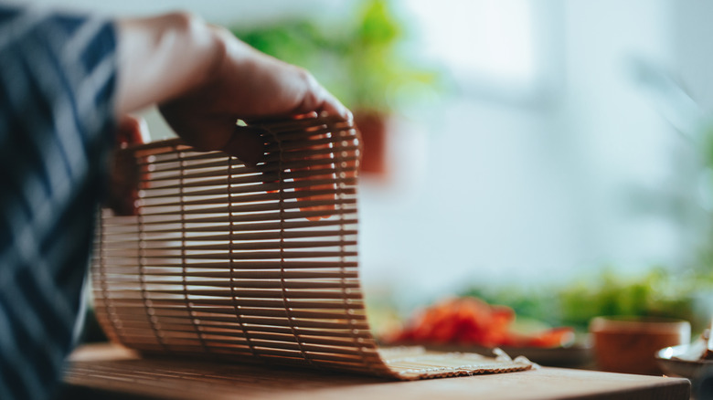 Woman holding sushi mat