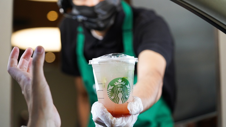 Worker handing customer Starbucks drink