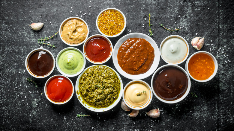 Bowls displaying a variety of condiments, sauces, and dips