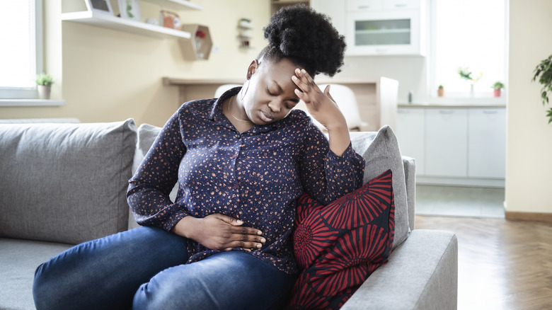 woman on a couch feeling sick 