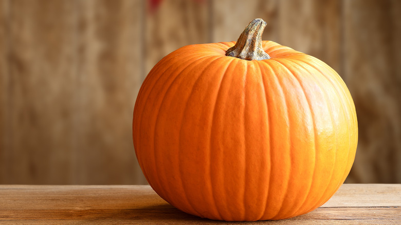 Orange pumpkin on rustic wood background