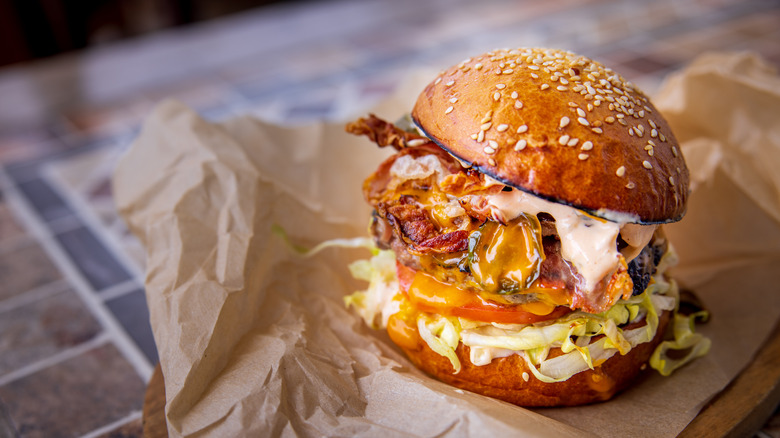 Cheeseburger on buns with bed of lettuce and tomato