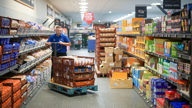 An employee stocks shelves at Aldi