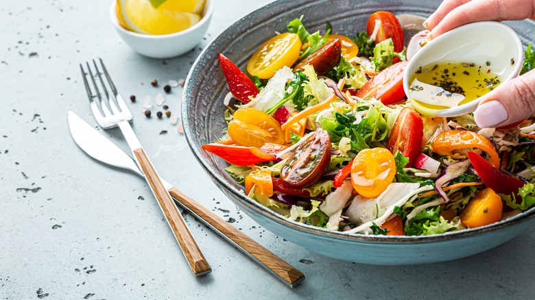 salad being dressed with olive oil