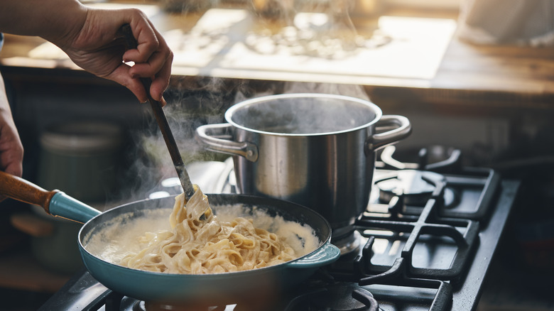 Person cooking fettuccine alfredo