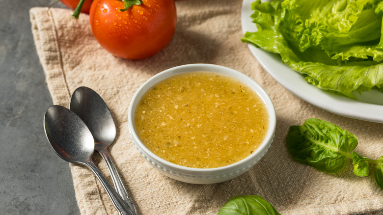 italian dressing in a bowl next to two spoons