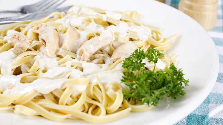 fettuccine alfredo with chicken on white plate