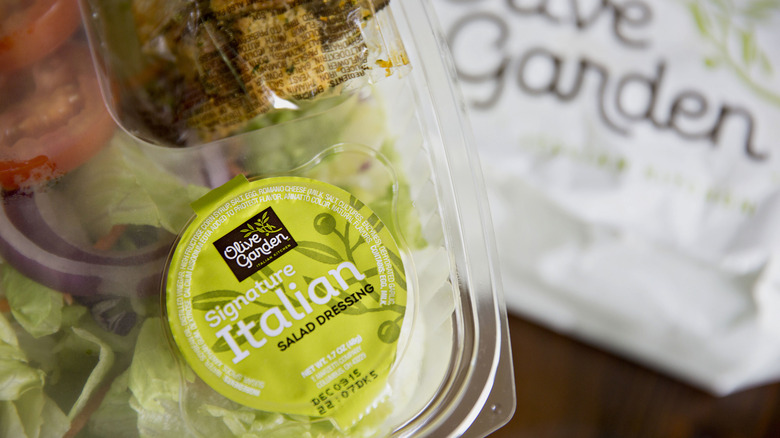 Olive Garden salad in takeout packaging close up