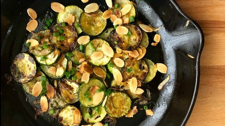 a finished dish of sauted zucchini with slivered almonds and herbs