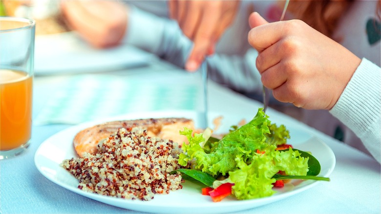 Quinoa, fish, and salad on plate  