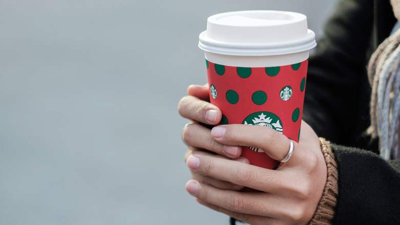 Woman holding Starbucks coffee