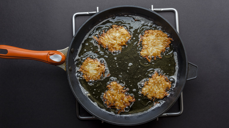 Frying latkes in oiled pan