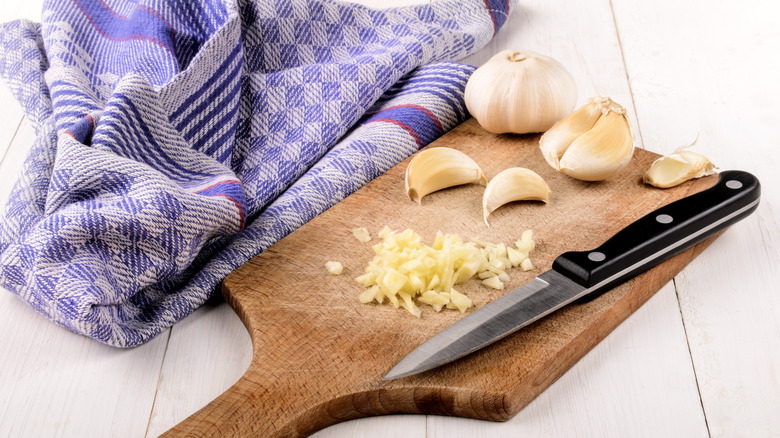 Garlic on a cutting board with a knife