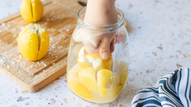 Hand in preserved lemon jar