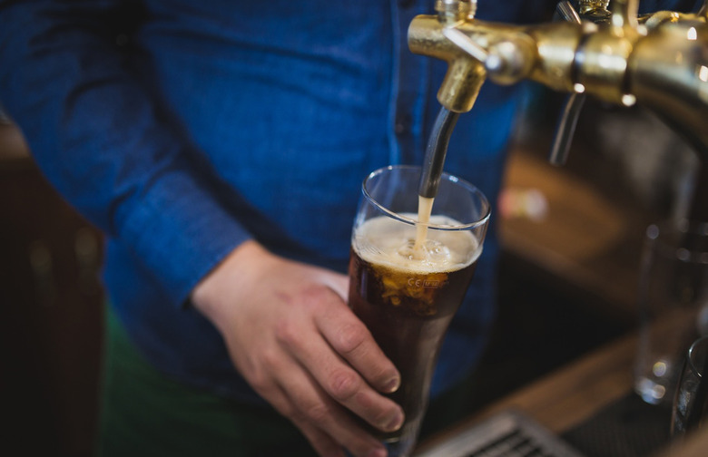 a-bottle-of-beer-sitting-on-top-of-a-table-next-to-a-glass-filled-with