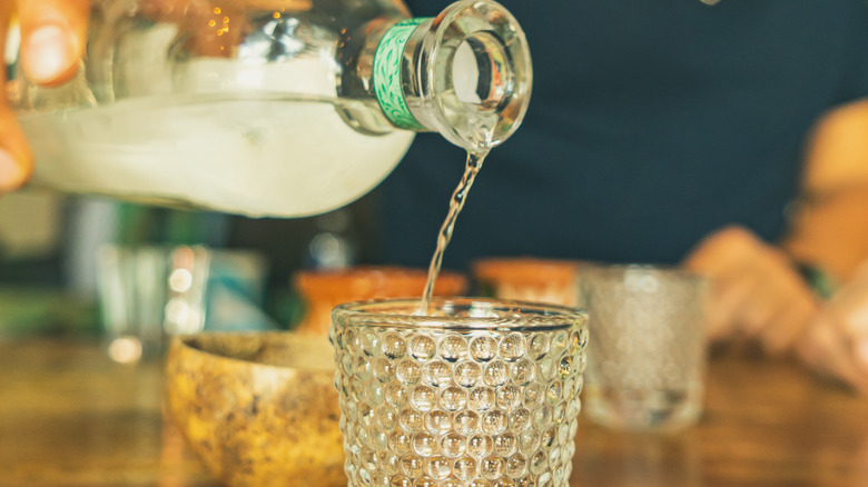 clear liquor being poured into glass