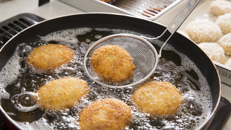 Person frying food in oil