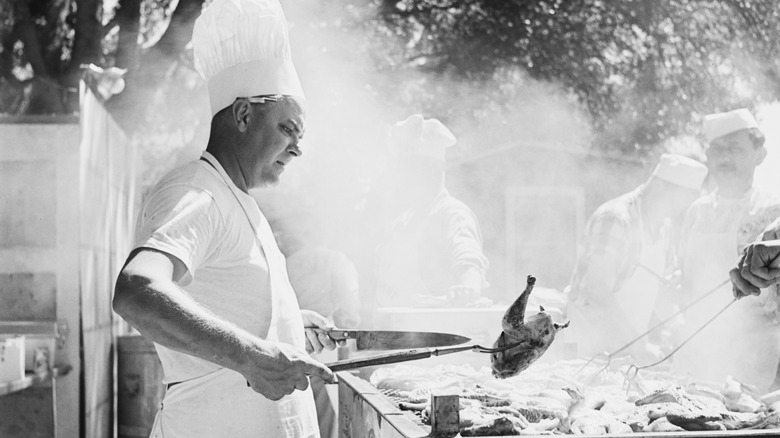 Man grilling chicken on barbecue