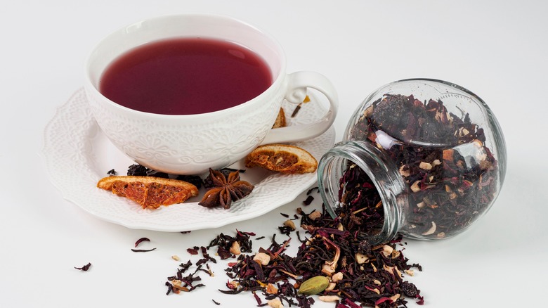 mug of black tea with dried tea leaves 