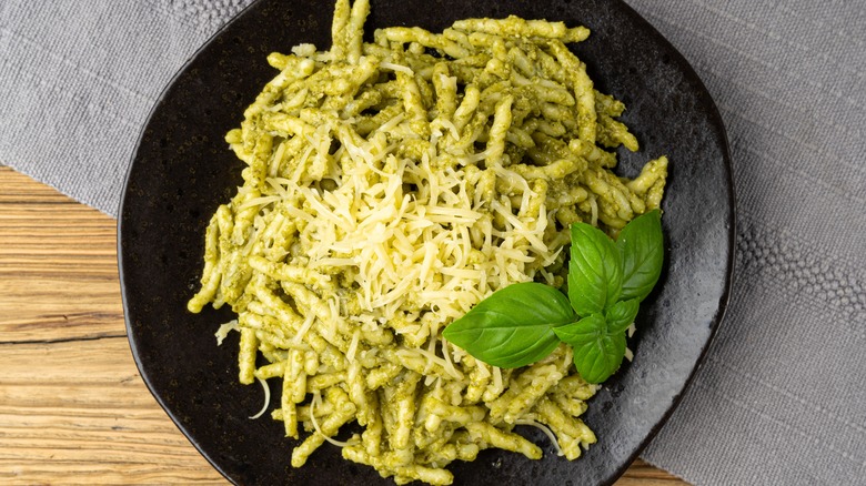 Pesto pasta in black bowl on table