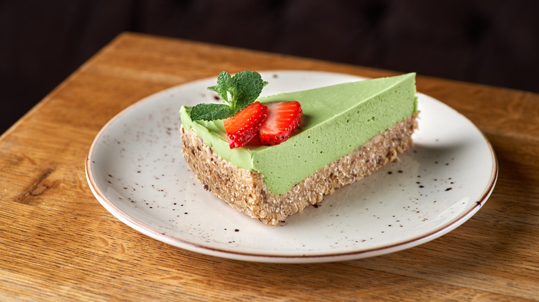 Lime green cheesecake with strawberries and mint