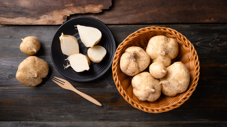 Raw, whole jicama with halved pieces in bowls