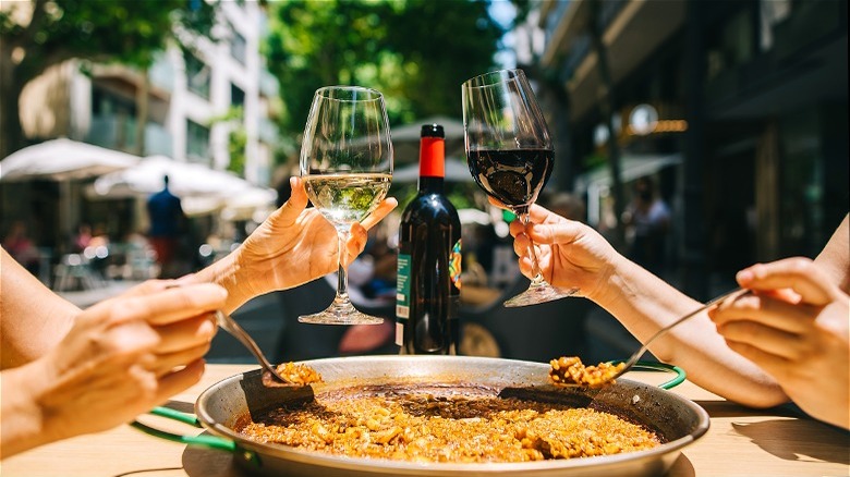 Two hands with wine glasses over food