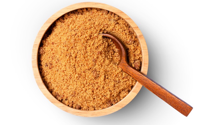 Soft light brown sugar in a wood bowl with spoon