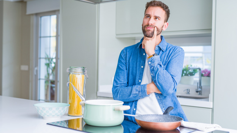 Man in kitchen thinking