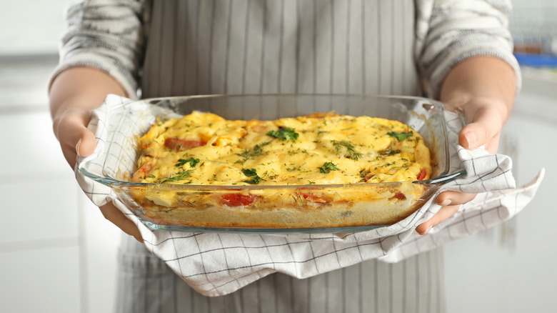 Person holding casserole with towel