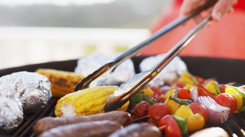 tongs turning food on the grill