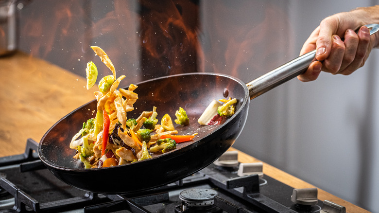 A person cooking with a wok