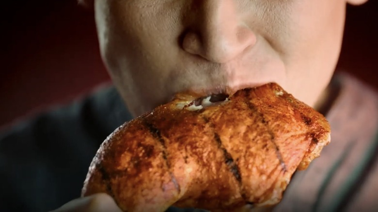 man eating KFC grilled chicken