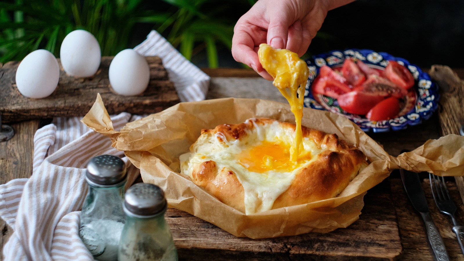 https://www.thedailymeal.com/img/gallery/khachapuri-the-georgian-dish-sure-to-elevate-your-eggs/l-intro-1697204010.jpg