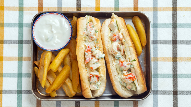 two lobster rolls and fries on a tray