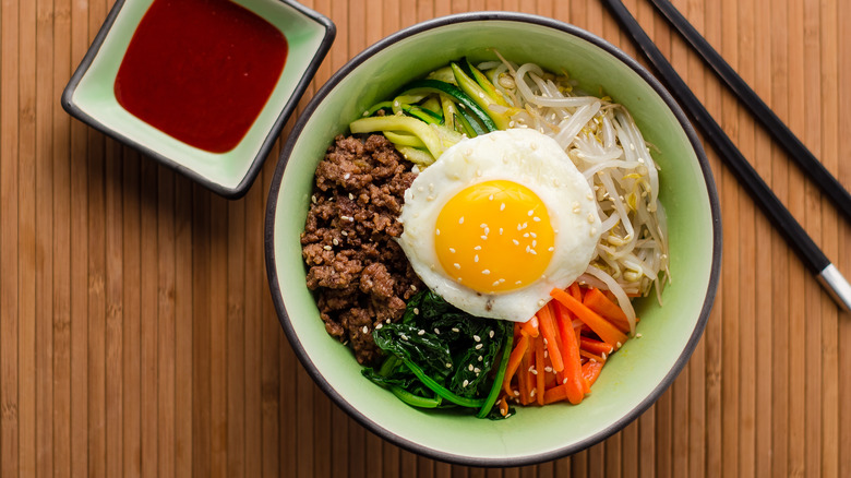 Bibimbap in bowl and a dipping sauce on the side