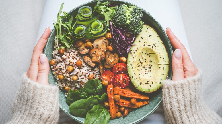 A person holding a plate of rimmed food