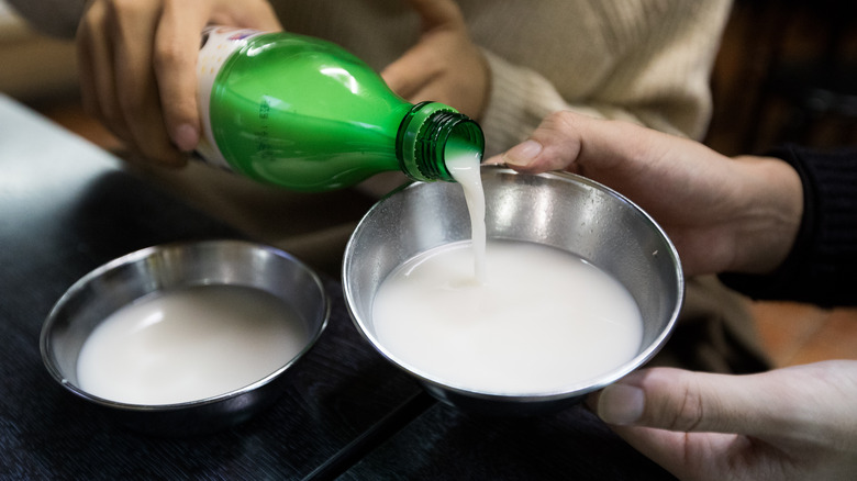 Hand pouring makgeolli into bowl