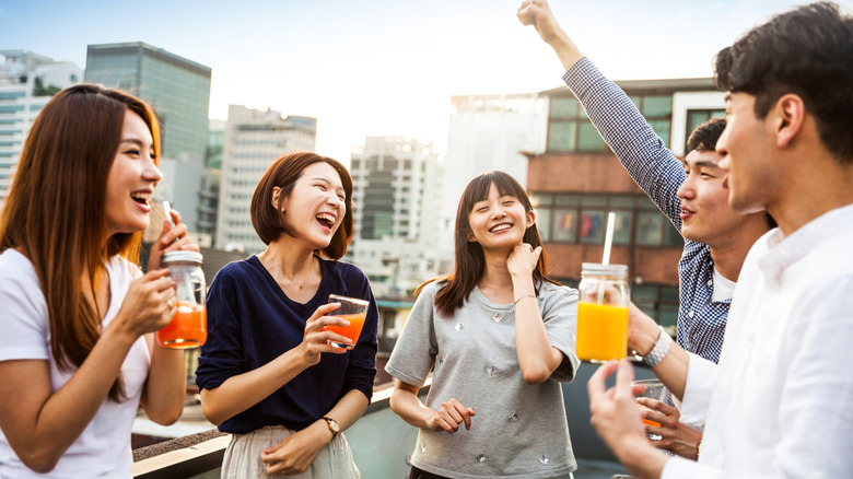 A group of Asian people drinking and laughing