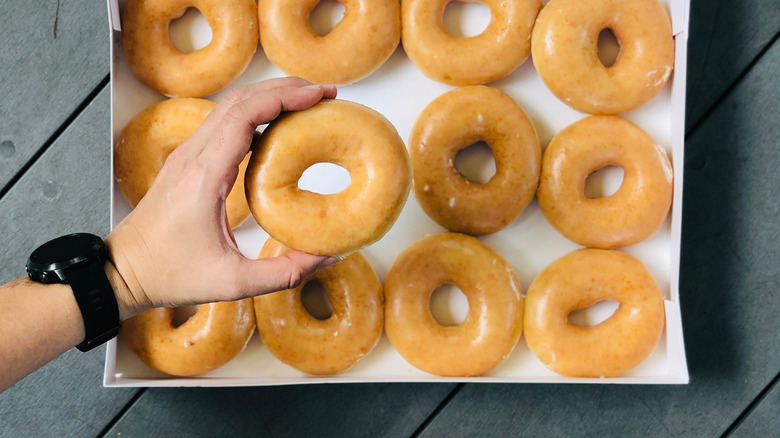 Person holding Krispy Kreme Doughnut