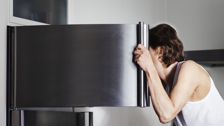 Person peering in kitchen freezer